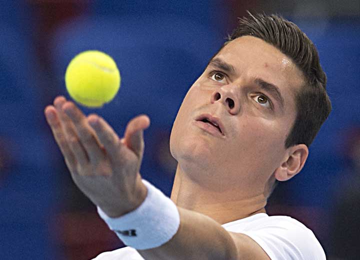 Milos Raonic serves a ball to Steve Johnson during their first round match at the Swiss Indoors tennis tournament at the St. Jakobs hall in Basel, Switzerland, on Tuesday, Oct. 21, 2014. 