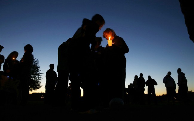 People hold candles as they gather for an anti-bullying rally Sunday, Oct. 12, 2014, in Sayreville, N.J.