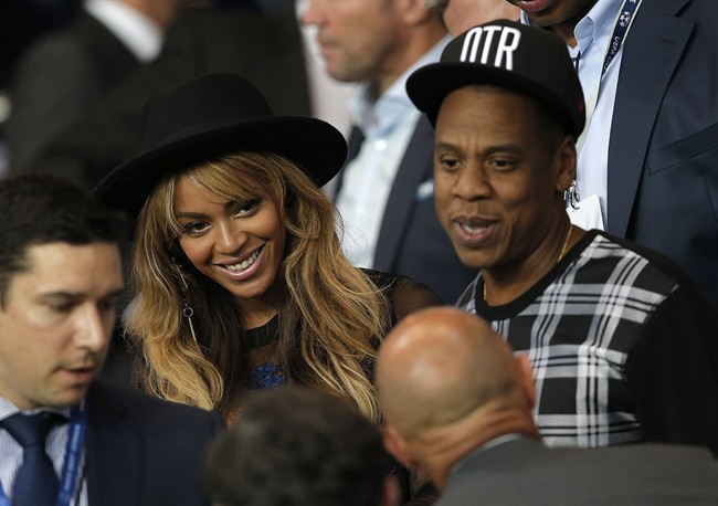 FILE - In a Tuesday, Sept. 30, 2014 file photo, Beyonce and her husband Jay Z stand up at half time in the Champions League soccer match between PSG and Barcelona, at the Parc des Princes stadium, in Paris. Beyonce announced Monday, Oct. 27, 2014 that she is merging with British retailer Topshop to launch an exercise clothing company, Parkwood TopShop Athletic Ltd. The clothing line will be available next fall. 