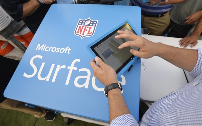 In this Aug. 3 2014 file photo, John Nisi, chief technology officer for Microsoft, works on a Surface tablet before the New York Giants play the Buffalo Bills at the Pro Football Hall of Fame exhibition NFL football game in Canton, Ohio.