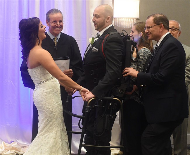 Jordan Basile, left, and Matt Ficarra, center, exchange wedding vows Saturday, Oct. 18, 2014, at the Doubletree hotel in Syracuse, N.Y.