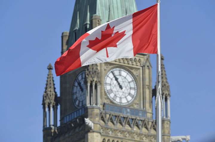 A file photo of the Canadian flag in front of Parliament.