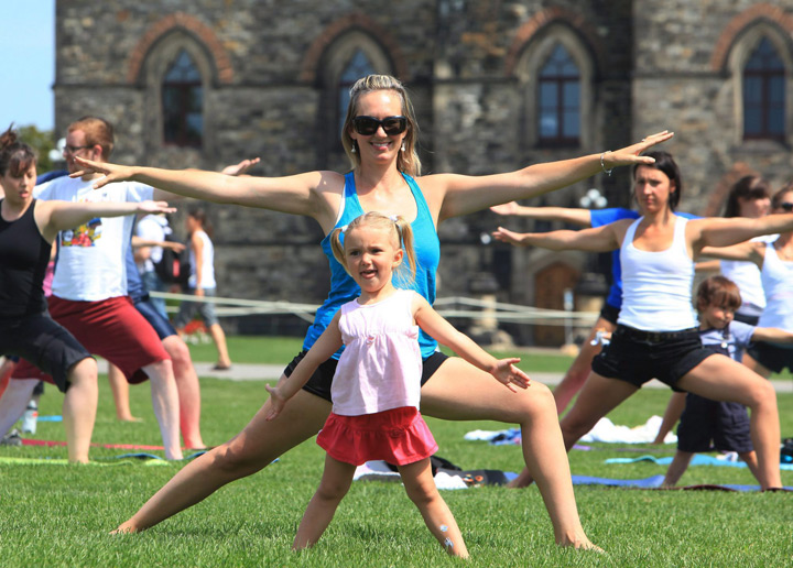 A mother and daughter practice yoga on Parliament Hill