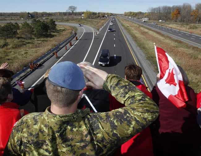 A Canadian Soldier salutes the hearse carrying the body of Cpl. Nathan Cirillo on the Veterans Memorial Highway in Ottawa on Friday, October 24, 2014. 