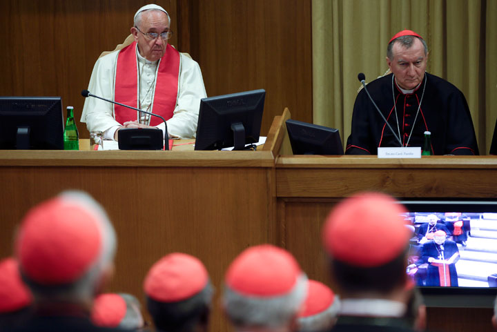 Pope Francis sits beside Vatican Secretary of State Cardinal Pietro Parolin as he leads a consistory expanded to include a briefing on the situation in the Middle East, at the Vatican, Monday, Oct. 20, 2014.