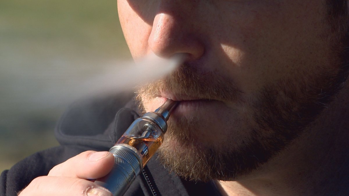 A man inhales vapour from an e-cigarette.