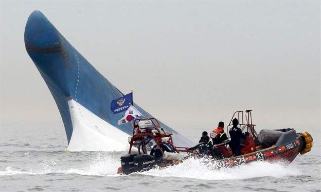 In this April 16, 2014 file photo, South Korean coast guard officers try to rescue passengers from the Sewol ferry as it sinks in the water off the southern coast near Jindo, south of Seoul, South Korea.