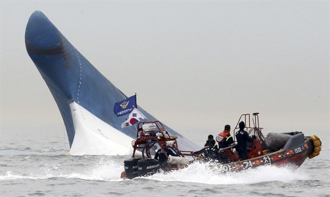 In this April 16, 2014 file photo, South Korean coast guard officers try to rescue passengers from the Sewol ferry as it sinks in the water off the southern coast near Jindo, south of Seoul, South Korea.
