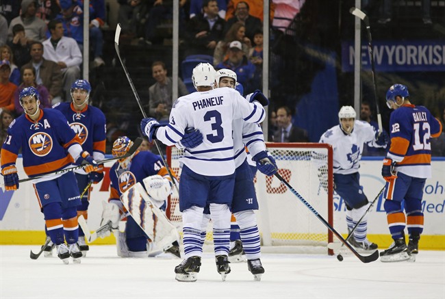 Toronto Maple Leafs defenseman Roman Polak embraces defenseman Dion Phaneuf (3) after Polak scored a goal on New York Islanders goalie Jaroslav Halak (41), of the Czech Republic, during the second period of an NHL hockey game in Uniondale, N.Y., Tuesday, Oct. 21, 2014.