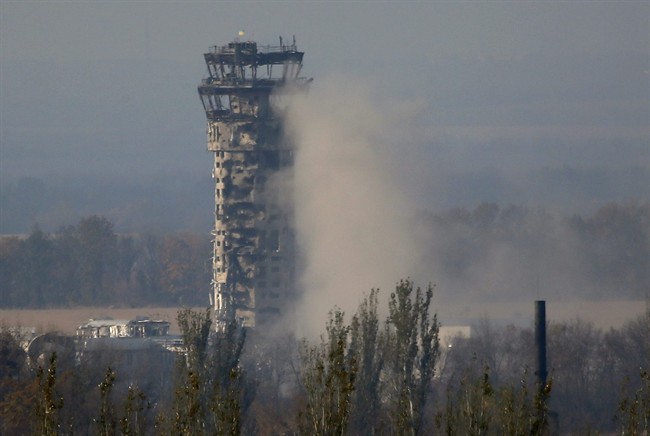 A Ukrainian flag flies over the traffic control tower of Donetsk Sergey Prokofiev International Airport during an artillery battle between pro-Russian rebels and Ukrainian government forces in the town of Donetsk, eastern Ukraine, Friday, Oct. 17, 2014. 