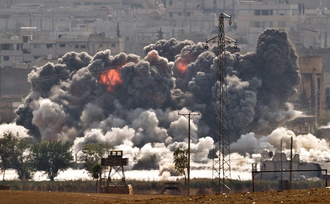 Smoke and flames rise from an Islamic State fighters' position in the town of Kobani during airstrikes by the US led coalition seen from the outskirts of Suruc, near the Turkey-Syria border, Tuesday, Oct. 28, 2014.