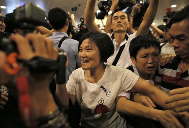 Pro-Beijing demonstrators try to approach pro-democracy protesters outside a government office in the Admiralty district in Hong Kong, Tuesday, Oct. 7, 2014. 