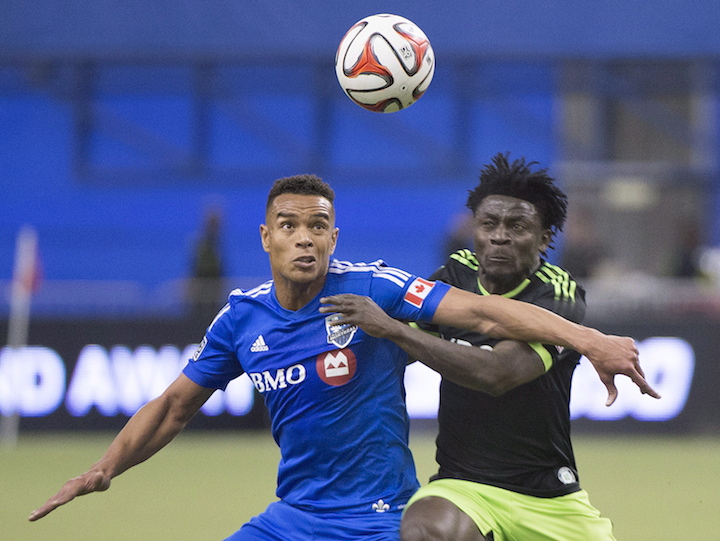 Montreal Impact's Matteo Ferrari, left, is challenged by Seattle Sounders' Obafemi Martins for the ball during second half MLS soccer action in Montreal, Sunday, March 23, 2014.