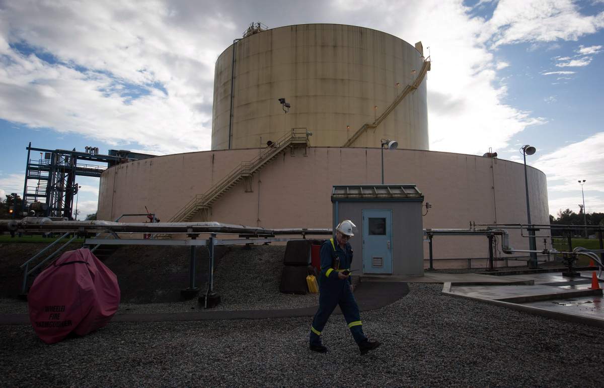 A FortisBC employee walks past a storage tank at the existing FortisBC Tilbury LNG facility before the groundbreaking for an expansion project in Delta, B.C., on Tuesday October 21, 2014. THE CANADIAN PRESS/Darryl Dyck.