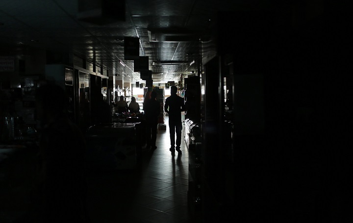 A Bangladeshi man walks in a shopping mall during a blackout in Dhaka, Bangladesh, Saturday, Nov. 1, 2014.