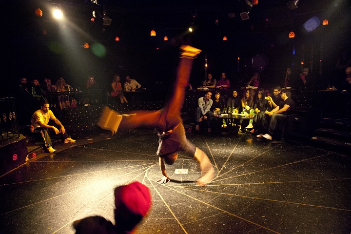 In this Thursday, Oct. 30, 2014 photo, a break dancer performs at a Halloween party in an upscale Damascus hotel, Syria. Amid a conflict grinding well into its fourth year, Syrians have sought to deny war its miserable monotony by taking pleasure in mindless entertainment, ranging from lounging in cafes, to dancing to thumping discos. 