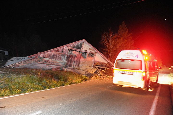 A fire department vehicle drives past a warehouse collapsed by a strong earthquake in Hakuba, Nagano Prefecture, central Japan, Saturday, Nov. 22.