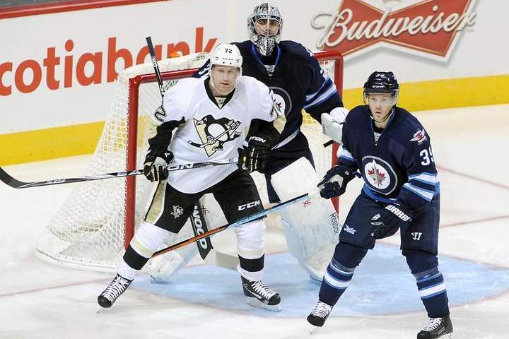 Patric Hornqvist of the Pittsburgh Penguins, goaltender Ondrej Pavelec and Toby Enstrom of the Winnipeg Jets keep an eye on the play during second-period action on Thursday at the MTS Centre in Winnipeg.