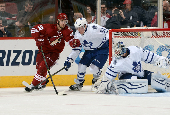  Antoine Vermette #50 of the Arizona Coyotes skates with the puck from behind the net as Jake Gardiner #51 of the Toronto Maple Leafs defends in front of goaltender James Reimer #34 of the Leafs during the third period at Gila River Arena on November 4, 2014 in Glendale, Arizona.  