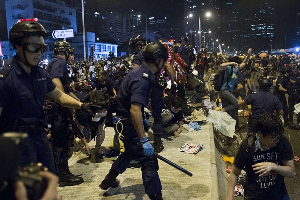 Police charge towards pro-democracy protesters near the government headquarters in the Admiralty district of Hong Kong early on December 1, 2014. Police unleashed pepper spray and baton charges at students who tried to storm Hong Kong's government headquarters early on December 1, as tensions soared in the third month of pro-democracy protests.  
