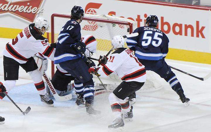 Adam Lowry and Mark Scheifele (55) of the Winnipeg Jets watch as the puck flies into the net for a second-period goal against the New Jersey Devils on Tuesday at the MTS Centre in Winnipeg. The goal was credited to Scheifele, his third of the season.
