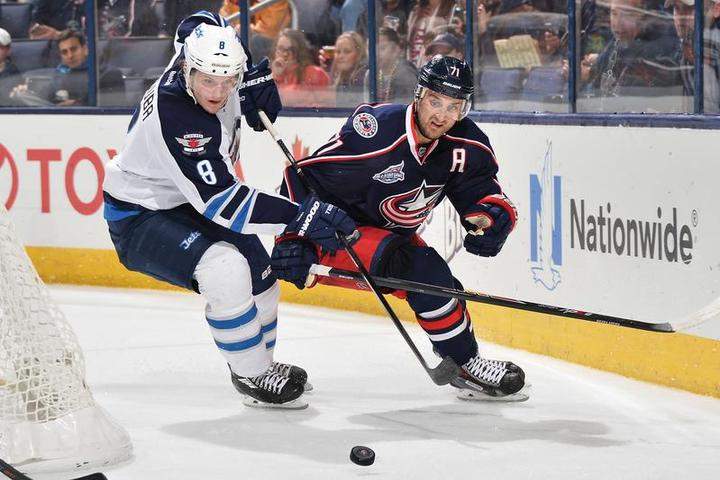 Jacob Trouba of the Winnipeg Jets and Nick Foligno of the Columbus Blue Jackets skate after a loose puck during the third period on Tuesday at Nationwide Arena in Columbus, Ohio. Winnipeg defeated Columbus 4-2.