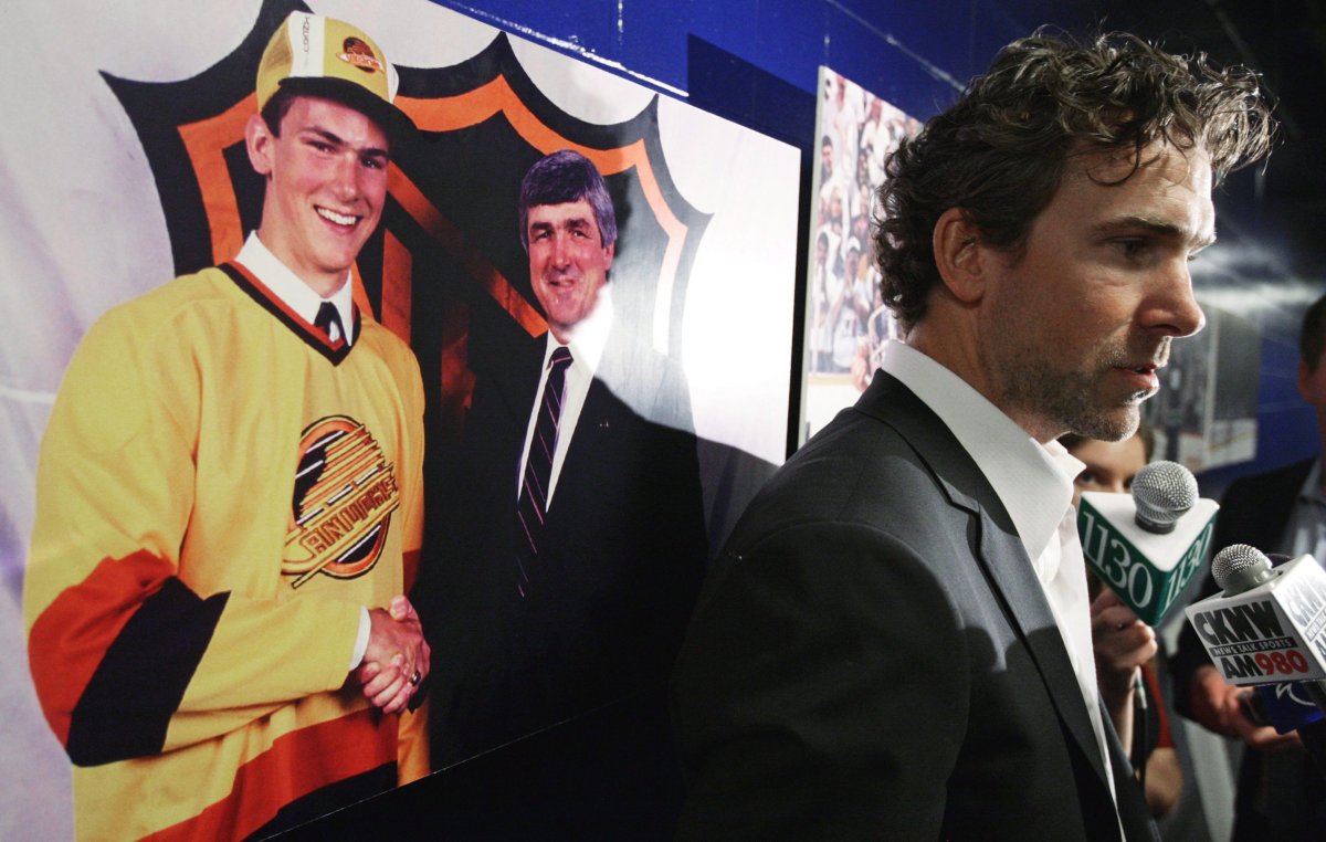 Vancouver Canucks' Trevor Linden is interviewed after announcing his retirement as a photograph of himself with Pat Quinn at the NHL entry draft in 1988 hangs on the wall behind him, in Vancouver, B.C., on Wednesday June 11, 2008. THE CANADIAN PRESS/Darryl Dyck.