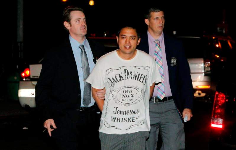 Officers escort Adam Tang to central police booking in New York's Manhattan borough after his arrest last year. 