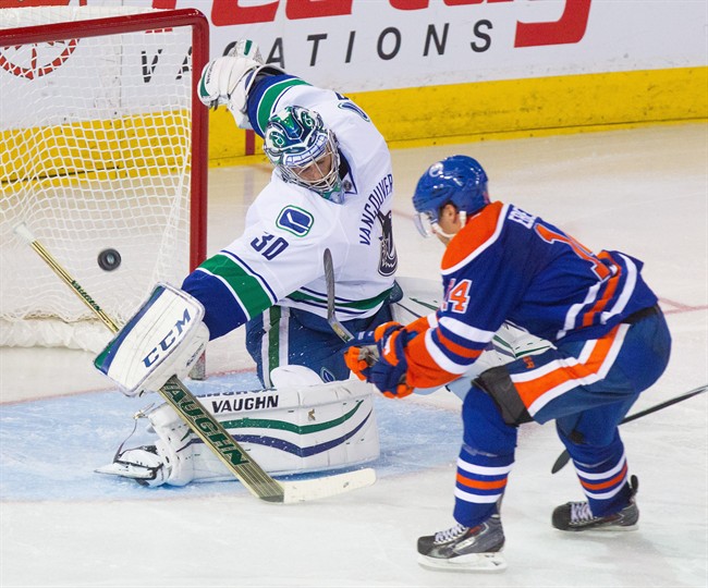 Vancouver Canucks goalie Ryan Miller(30) makes a save on Edmonton Oilers Jordan Eberle (14) during third period NHL hockey action in Edmonton, Alta., on Saturday November 1, 2014. The Canucks won 3-2.