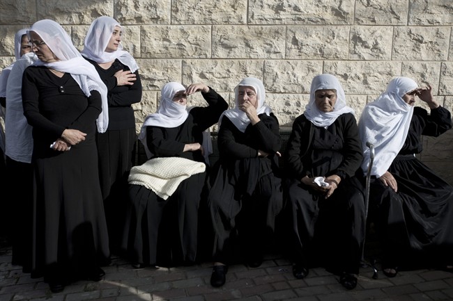 Druze women mourn during the funeral of Druze Israeli police officer Zidan Sif in the Druze village of Yanuh-Jat, northern Israel, Wednesday, Nov. 19, 2014. 