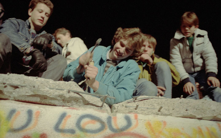 An East German youth chips away the wall with a chisel and a hammer as East and West German citizens celebrate as the opening of the East German border was announced in Nov.10, 1989.