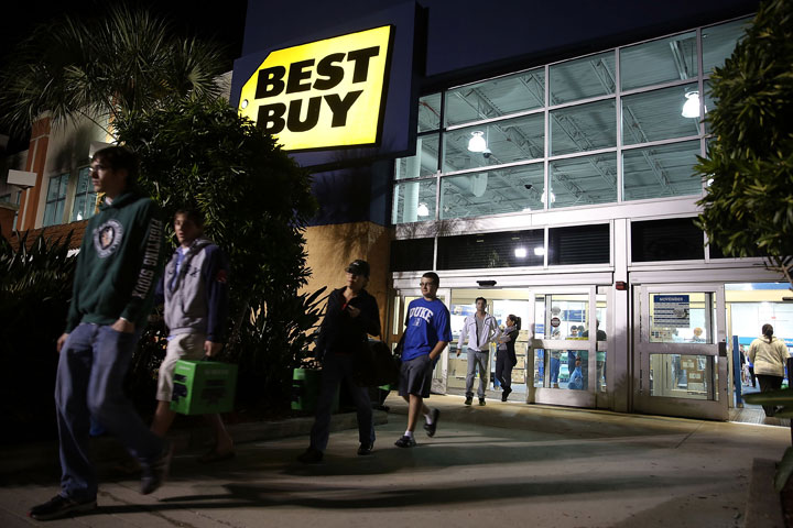 Black Friday shoppers carry away discounted items from a Best Buy store which opened its doors at 6pm on Thanksgiving Day this year on November 29, 2013 in Naples, Florida. 
