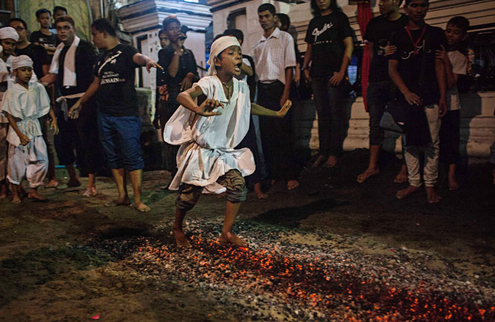 Shi’ite Muslim boys do a fire walk during the second night of Ashura, a commemoration involving running over fiery coals to mourn the martyrdom of Husayn ibn Ali, the grandson of Muhammad on November 3, 2014 in Yangon, Burma. Ashura is on the tenth day of Muharram in the Islamic calendar and marks the climax of the Remembrance of Muharram.