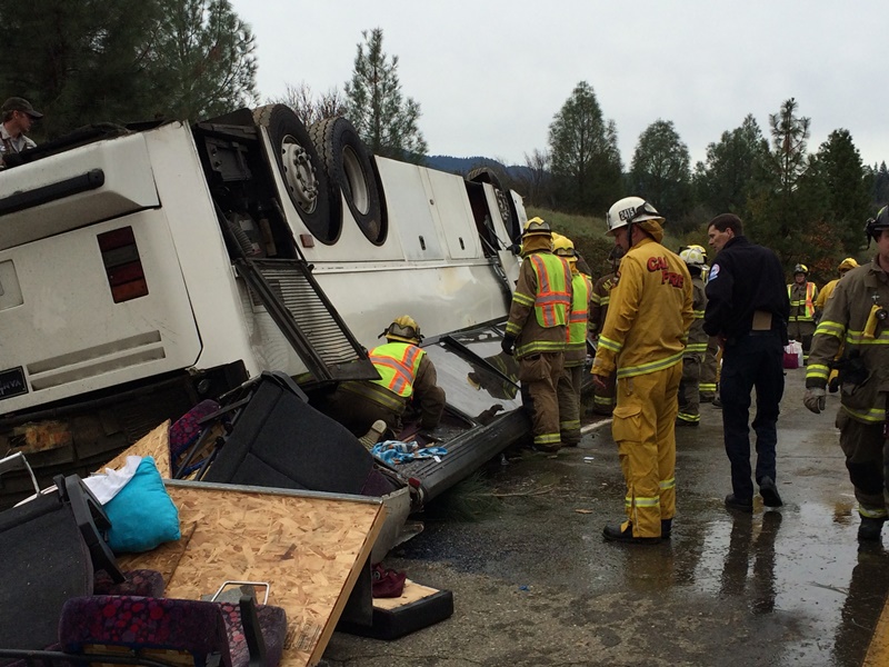 Emergency personnel check a tour bus that had already crashed earlier in the day overturned just off Interstate 5 in Northern California, killing one person and sending dozens to hospitals near the Pollard Flat area in Redding, Calif., Sunday, Nov. 23, 2014.  