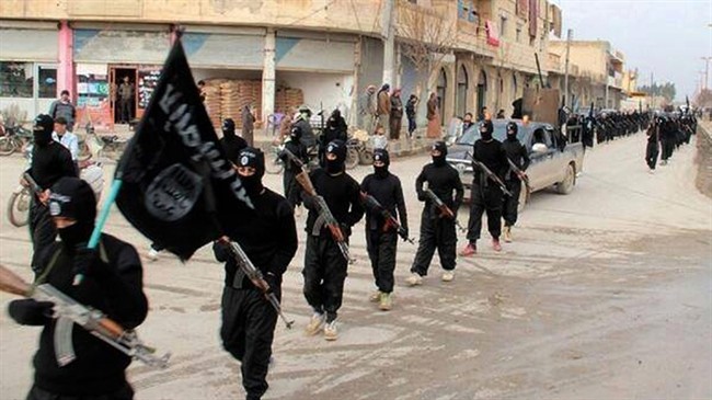 Members of ISIS march through Raqqa, Syria .