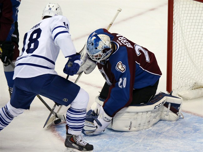 Toronto Maple Leafs right wing Richard Panik, left, of Slovakia, has his shot stopped by Colorado Avalanche goalie Reto Berra, right, of the Czech Republic, in the first period of an NHL hockey game in Denver, Thursday, Nov. 6, 2014. (AP Photo/David Zalubowski).