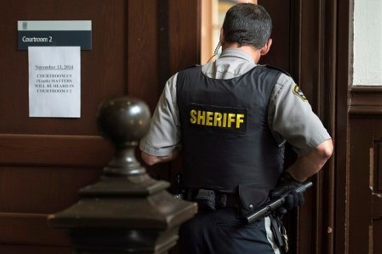 A sheriff's deputy stands outside youth court at provincial court in Halifax on Thursday, November 13, 2014. A young man who pleaded guilty in a prominent child pornography case in Halifax has been given a conditional discharge and will be registered in the national DNA databank. THE CANADIAN PRESS/Andrew Vaughan.