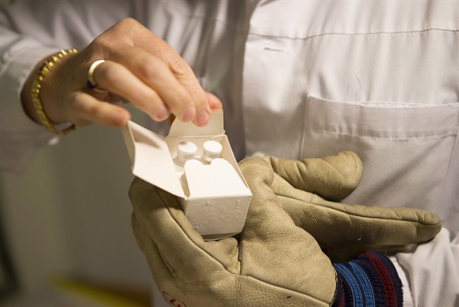 A WHO worker opens a box the Canadian-made Ebola vaccine at the Geneva Hospital on Oct. 22, 2014.