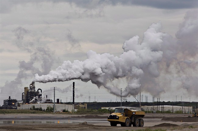 A dump truck works near the Syncrude oil sands extraction facility near the town of Fort McMurray, Alberta on Sunday June 1, 2014.