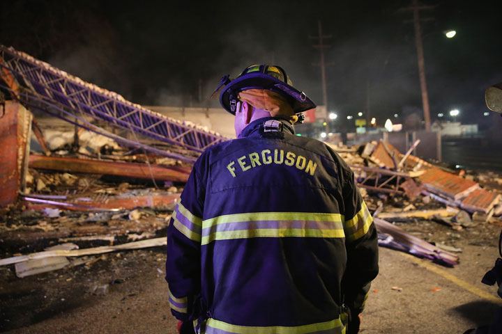 A Ferguson firefighter surveys rubble at a strip mall that was set on fire when rioting erupted following the grand jury announcement in the Michael Brown case on November 25, 2014 in Ferguson, Missouri. 