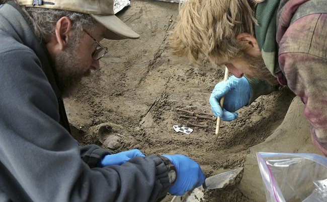 In this Fall 2013 photo released Tuesday, Nov. 11, 2014 by the University of Alaska Fairbanks, professors Ben Potter, left, and Josh Reuther excavate the burial pit at the Upward Sun River site in central Alaska. Researchers have uncovered the remains of two Ice Age infants in Alaska's interior, a discovery archaeologists call the youngest human remains found in northern North America.