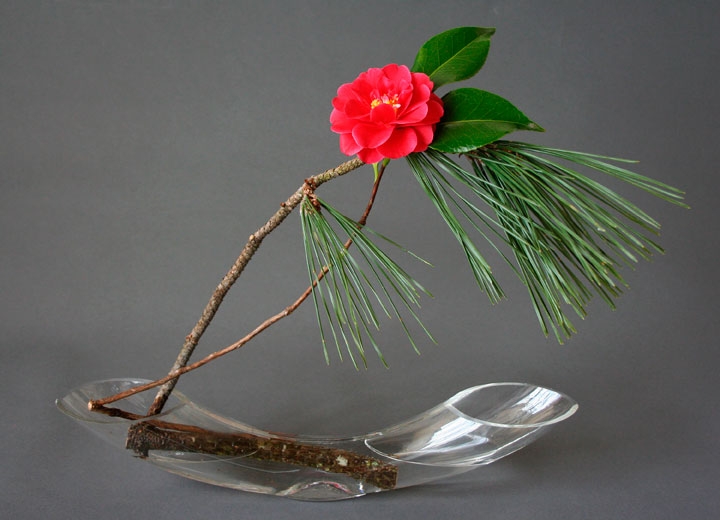 This photo provided by KeithStanley.com shows Ikebana using pine and red camellia branches.The ancient Japanese art of ikebana, or flower arranging, can offer lots of festive sparkle and color for the holidays - and a more modern feel that celebrates asymmetry, space and naturalism.