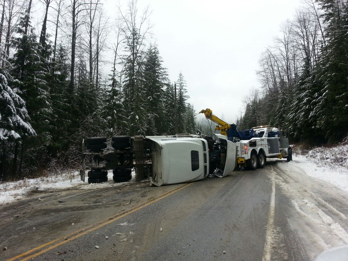 Crews tend to a trailer tractor that lost control on Highway 1 and tipped over on Saturday morning, blocking traffic for several hours.