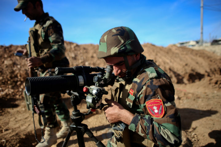 A Kurdish Peshmerga fighter uses a scope to measure the distance during fighting against Islamic State (IS) group on November 8, 2014 in the Syrian besieged border town of Kobani. 