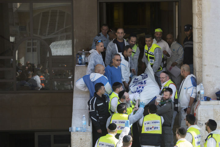 Israeli rescue workers carry a body at the scene of a shooting attack in a Synagogue in Jerusalem, Tuesday, Nov. 18.