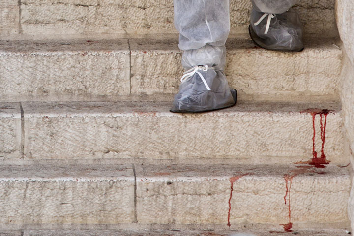 An Israeli rescue worker navigates the scene of a shooting attack in a synagogue in Jerusalem, Tuesday, Nov. 18, 2014. (AP Photo/Sebastian Scheiner)
