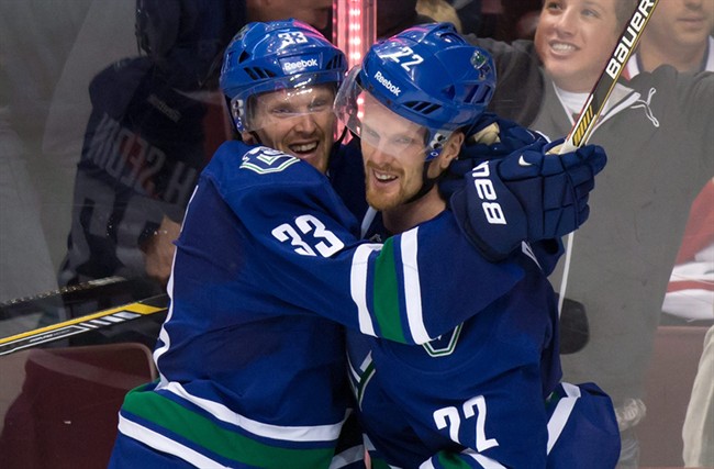 FILE - This Oct. 30, 2014, file photo shows Vancouver Canucks' Daniel Sedin, right, celebrating with his twin brother Henrik Sedin. (AP Photo/The Canadian Press, Darryl Dyck,File).