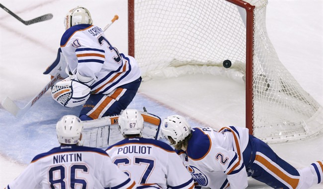 Edmonton Oilers goalie Ben Scrivens and his teammates watch as the puck, shot by Boston Bruins center Carl Soderberg, of Sweden, lands in the back of the net for a goal during the third period of an NHL hockey game, Thursday, Nov. 6, 2014. The Bruins defeated the Oilers 5-2. 
