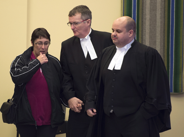 Rose Margaret Boudreau leaves court accompanied by Crown attornies Shane Russell, right and Steve Drake after jurors reached a verdict in the Joseph James Landry murder case in Port Hawkesbury, N.S. on Saturday, Nov. 29, 2014. Landry was convicted of manslaughter in the death last year of her brother, Philip Boudreau, whose body hasn't been found.