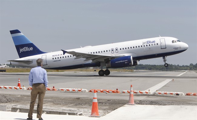 FILE - In this June 2, 2010 file photo, a man watches a JetBlue airplane take off from John F. Kennedy International Airport in New York. 